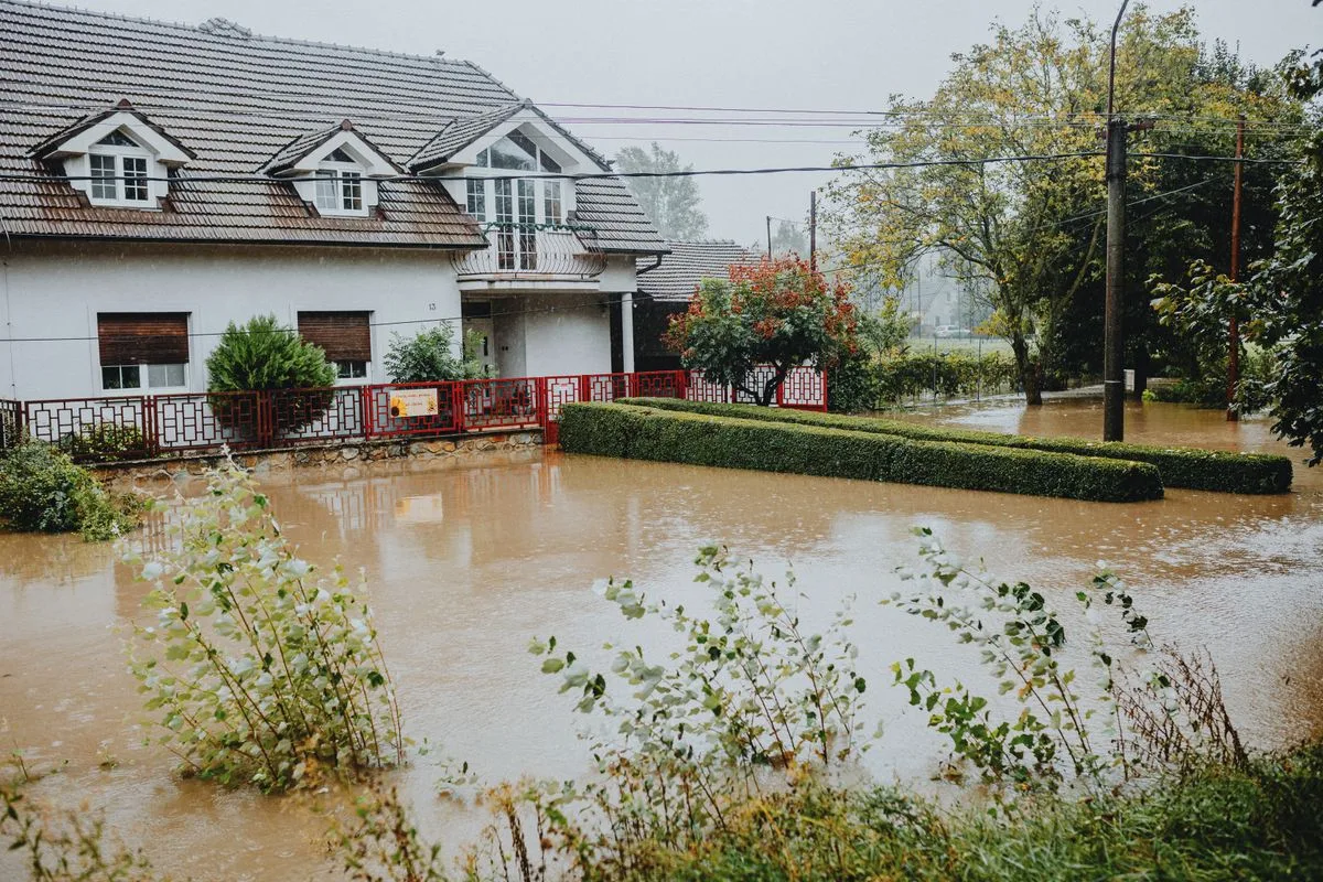 Floodwater filling the front yard of a home during a storm